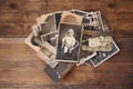 Old vintage monochrome photographs in sepia color are scattered on a wooden table, the concept of genealogy, the memory of