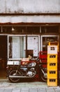 Old vintage motorcycle behind local restaurant with colourful be Royalty Free Stock Photo