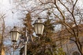 Old vintage Odessa street light lanterns in front of spring tree branches in warm evening sun light Royalty Free Stock Photo
