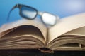 Old vintage opened book with glasses Royalty Free Stock Photo