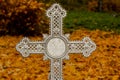 Old vintage orthodox cross on grave against autumn fallen leaves Royalty Free Stock Photo