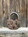 Old vintage padlock. Against the background of an old wooden shed.
