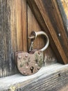 Old vintage padlock. The lock of the lock is open. Nearby is the key to the padlock. Against the background of an old wooden shed. Royalty Free Stock Photo