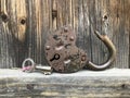 Old vintage padlock. The lock of the lock is open. Nearby is the key to the padlock. Against the background of an old wooden shed. Royalty Free Stock Photo