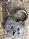 Old vintage padlock. The lock of the lock is open. Nearby is the key to the padlock. Against the background of an old wooden shed. Royalty Free Stock Photo