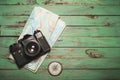 Old vintage photo camera with compass and map on wooden background Royalty Free Stock Photo