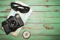 Old vintage photo camera with map, compass and dark glasses on wooden background Royalty Free Stock Photo