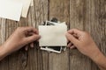 Old vintage photo template mockup in hands on wooden background. Empty retro card, textured paper Royalty Free Stock Photo