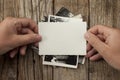 Old vintage photo template mockup in hands on wooden background. Empty retro card, textured paper Royalty Free Stock Photo