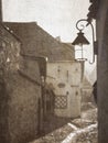 Old vintage picture of a street lamp and the cobblestone streets in the medieval citadel of Sighisoara Royalty Free Stock Photo