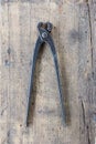 Old vintage pliers pincers against. wooden plank. Royalty Free Stock Photo