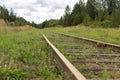 Old vintage railroad with wooden sleepers overgrown with grass