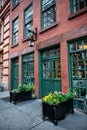 Old vintage red bricks commercial building with restaurant inside and green wooden doors. Royalty Free Stock Photo