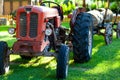 An old red tractor near a farm field. Royalty Free Stock Photo