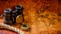 Old vintage retro compass and spyglass on ancient world map