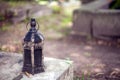 Old vintage rusted lantern standing on a gravestone with a blurred background