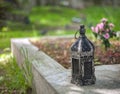 Old vintage rusted lantern standing on a gravestone with a blurred background
