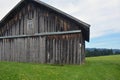 Old vintage rustic barn or shed on green grass. Picturesque nature outside the city Royalty Free Stock Photo