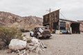 Old vintage rusty car truck abandoned near abandoned gas station. Royalty Free Stock Photo