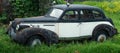 Old vintage rusty retro car in green grass