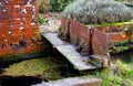 Old vintage rusty sluice gates across brick built stream in rural setting. Royalty Free Stock Photo