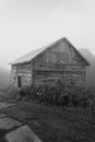 Old vintage sawn log cabin in the fog bw Royalty Free Stock Photo