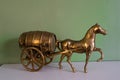 Old vintage style bronze horse and cart barrel on a shelf with a green background. Home dÃÂ©cor, ornament, fashion style,