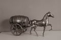 Old vintage style bronze horse and cart barrel on a shelf with a muted background. Home dÃÂ©cor, ornament, fashion style,