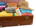 Old vintage suitcase packed with clothes and vacation accessories