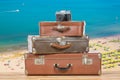 Old vintage suitcases with retro film camera against nice sea and beach white background. Travel or vacation concept. Royalty Free Stock Photo