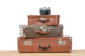Old vintage suitcases with retro photo camera on light wooden table on a white background. Travel concept. Royalty Free Stock Photo