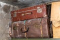 Old vintage suitcases on a shelf in abandoned garage. Corrosion on locks and handle. Dust and cobwebs on the walls.