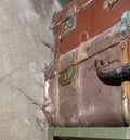 Old vintage suitcases on a shelf in abandoned garage. Corrosion on locks and handle. Dust and cobwebs on the walls.