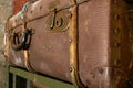 Old vintage suitcases on a shelf in abandoned garage. Corrosion on locks and handle. Dust and cobwebs on the walls.