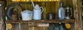 Old vintage tableware on a wooden shelf, some rusty old cups and plates, historical and primitive equipment