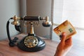 Old vintage telephone on a desk with money in hand Royalty Free Stock Photo