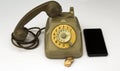 old vintage telephone and telephone tokens with a smartphone next to it. Old and new in comparison Royalty Free Stock Photo