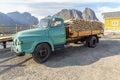 Old vintage truck filled with Stockfish near yellow rorbu in Lofotens, Norway