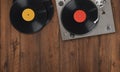 Old vintage turntable with vinyl records on a wooden table. Top view