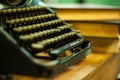 Old and vintage type writer machine and piles of books on wooden table - very selective focus. Royalty Free Stock Photo