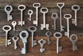 Old vintage various keys pattern. Antique metal gold bronze silver color different clue for padlock. Set on brown wooden