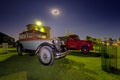 Old vintage vehicles park under a full moon at Sandstone Estates