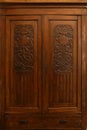 Old vintage wardrobe furniture with ornamental doors and retro colors of wooden surfaces Royalty Free Stock Photo