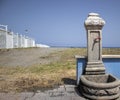 Old vintage water faucet on the beach on the Italian coast in sunny Calabria, Italy. Tap water against the beach. Faucet with