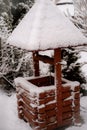 Old vintage well with a roof in the snow in winter