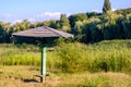 Old vintage wooden beach umbrella on abandoned, grassy and reed river beach on a sunny summer day Royalty Free Stock Photo