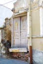 Old vintage wooden door with cracked paint in ruined ancient damaged uneven brick wall in destroyed house, building Royalty Free Stock Photo