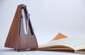 Old vintage wooden metronome near a music sheet Royalty Free Stock Photo