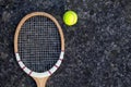 Old vintage wooden tennis racket on isolated stone background with green ball. Royalty Free Stock Photo