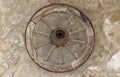 Old vintage wooden wheel hanging on a stone wall of a house Royalty Free Stock Photo